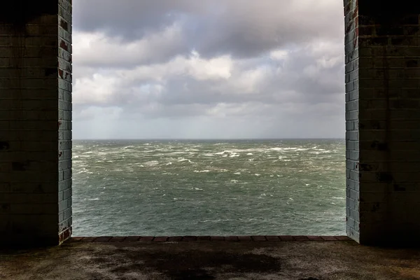 Stormachtige Zee Oceaan Omlijst Een Leeg Raam Van Verlaten Gebouw — Stockfoto