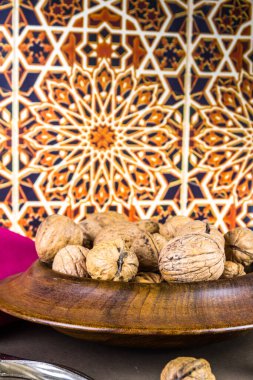 Tüm cevizler ahşap bir kaseye istiflenmiş, fındıkkıranlar yan yana, Fas arka planı, portre, üst üste kopyalanmış boşluk..
