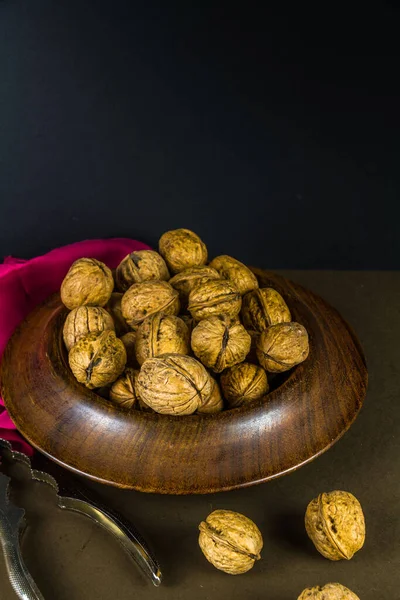 Whole Walnuts Piled Wood Bowl Some Scattered Nutcrackers Side Dark — Stock Photo, Image