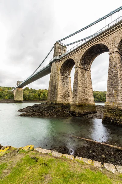 特尔福德 Thomas Telford 设计的梅奈悬索桥 Menai Suspension Bridge 穿过了位于威尔士斯诺多尼亚和安克雷西之间的梅奈海峡 成为了一幅肖像 — 图库照片