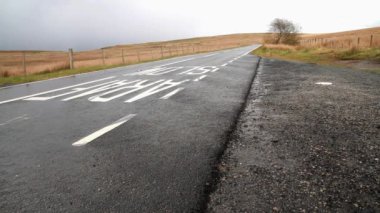 PENTREFOELAS, WALES MAYIS 72 2021: Pentrefoelas 'ın kuzeyi, Kuzey Galler, Çimenli bozkır boyunca A543 Yolu, yarış araçları için kötü şöhretli EVO Şeytan Üçgeni' nin bir parçası, araba virajda bir diğerini sollar, geniş açılı,.