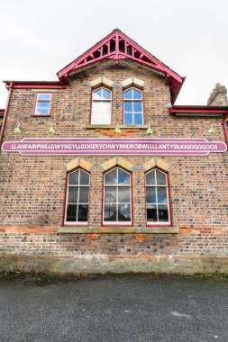 Llanfair Pwyngyll Llanfair Pwllgwyngyll ya da Llanfair pwygwyngyllgogerychwyrndrobwllllantysiliogogogogogogoch tabelasını tren istasyonuna asar. Anglesey, Galler, portre