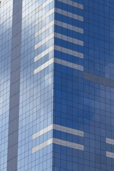 Rascacielos de cristal con cielo azul y nubes reflejadas en ventanas . — Foto de Stock