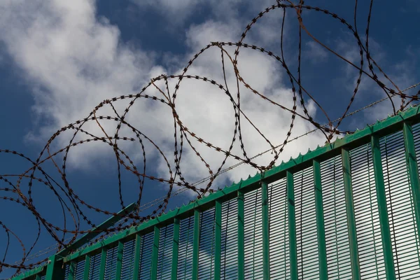 Yeşil üstüne dikenli tel çit koruma Fransız feribot terminaline. — Stok fotoğraf