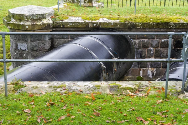 Obrovské černé potrubí převážení vody, Velká Británie. — Stock fotografie