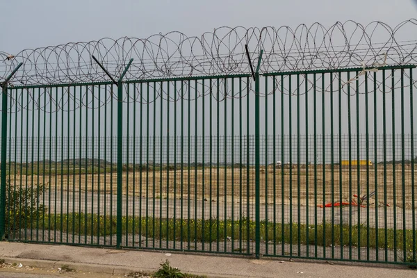 Groene hek met scheermes draad Franse veerboothaven bewaken. — Stockfoto