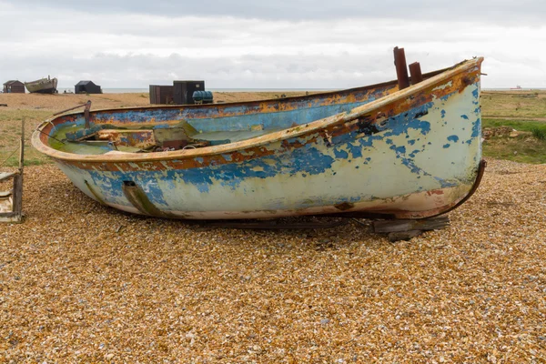 Régi, elhagyott csónak kavicsos strandon. — Stock Fotó