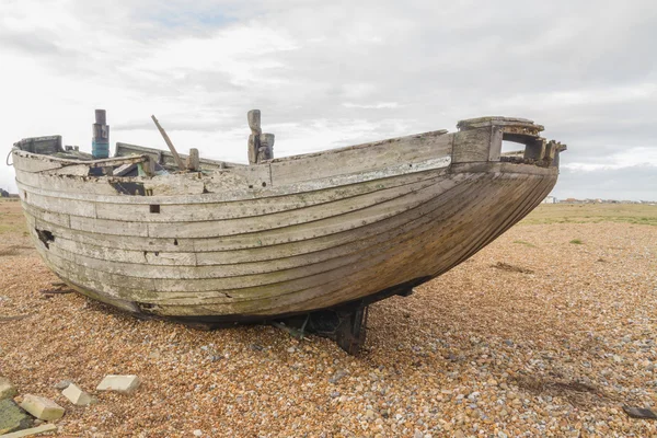 鹅卵石海滩上的废弃老船. — 图库照片