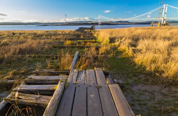 Remains of Aust Ferry pier with Severn Bridge in the distance — Stock Photo, Image
