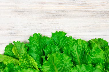 Beyaz ahşap bir masada taze yeşil salata. Yazı için uygun bir yer. Fto kapatılıyor.