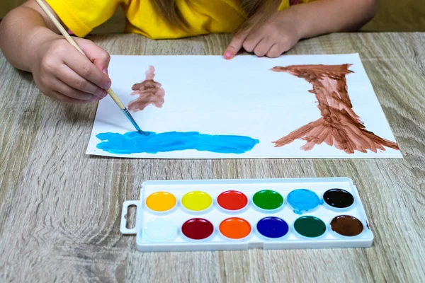 Zbliżenie dziecięcy ręka z pędzel rysunek i akwarela. Dzieci artysta rysuje, kreatywność, rekreacja, szkolenia, rysunek, kursy kolorów, malarstwo, badania kolorów. — Zdjęcie stockowe