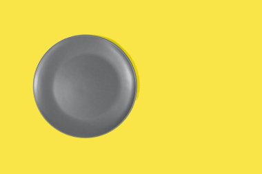 Parlak sarı arka planda gri bir çaydanlık. 2021 'in moda renklerini gösteriyor. Gri ve sarı. Bir yazıt için yer.