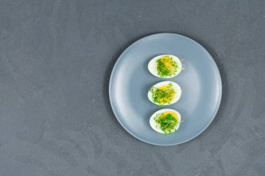 Yumurta üzerine mikroçerez. Salatayı mikro yeşil yapraklarla süsleyin. Diyet yemek. Taze taze otların yanında haşlanmış ve taze yumurtalar. Modern tarz salata. Yukarıdan bak. Bir yazıt için yer.