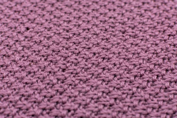 Knitted fabric pearl woolen background, close-up. The structure of the fabric with a natural texture. Fabric background. Knitted woolen background. Close-up.