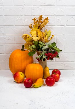 Sonbahar hasat geçmişini kapatın. Beyaz arka planda olgun balkabağı, elma, armut ve sonbahar yapraklarıyla dolu bir hayat.