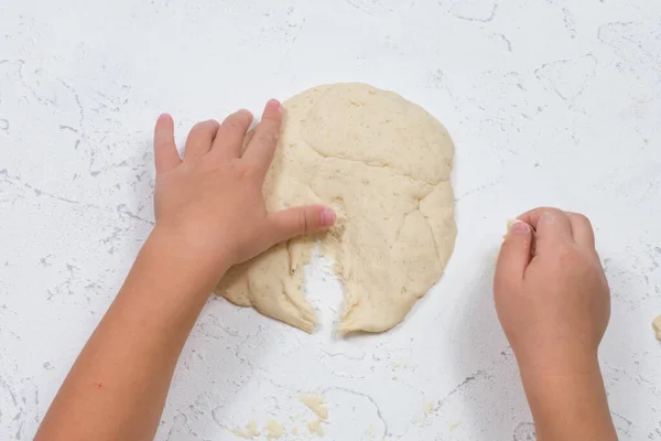 Childrens hands sculpt salty dough. Development of fine motor skills of the hands. Development of childrens creativity.
