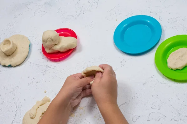 Las manos de los niños esculpen masa salada. Desarrollo de habilidades motoras finas de las manos. Desarrollo de la creatividad infantil. —  Fotos de Stock