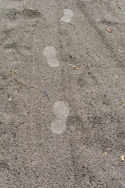 雨后在湿沙滩上留下多处脚印.湿沙中的脚印。沙地背景. — 图库照片