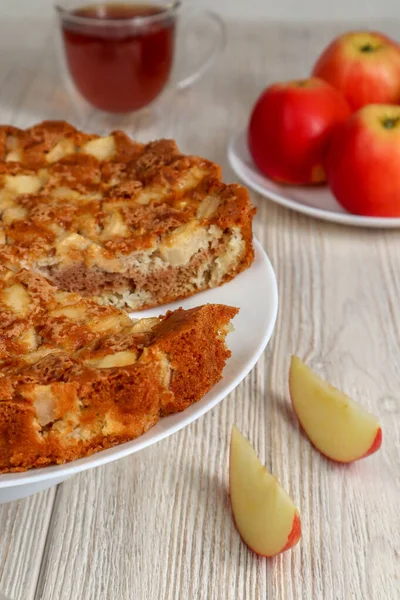 Elmalı turta ahşap bir masada kırmızı elmaların arka planına karşı..