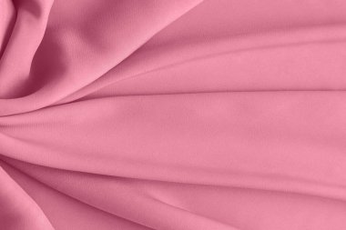 Gentle pink fabric texture with smooth drape and soft folds, suitable as a fashion or design background.