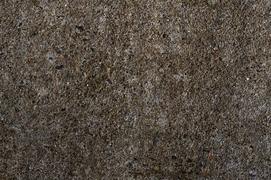 Cesur asfalt dokusu, koyu tonlar ve arkaplan için uygun dağınık çakıl taşlarının yakın plan görüntüsü.