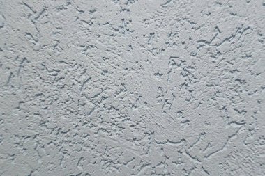 Tasarım ve arkaplan kullanımı için kabataslak, düzensiz yüzey gösteren beyaz desenli alçı duvarın yakın çekimi.