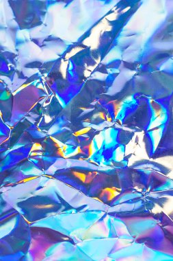 Işıldayan holografik folyo renkli, yansıtıcı desenler ve tasarım projeleri için uygun soyut arkaplan oluşturur.