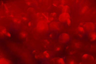 Kırmızı bokeh ışıkları yumuşak parıltı ve soyut dokuya sahip ılık, rüya gibi bir zemin oluşturur..