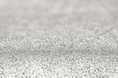 Gümüş parıltılı bir dokunun yakın çekimi metalik parlaklığa sahip yumuşak ve soyut bir arkaplan oluşturuyor. 2026 Yılının Gösteri Rengi.