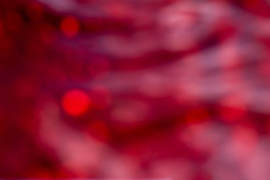 Bokeh ışıkları ile bulanık kırmızı arka plan sıcak, romantik bir soyut ruh hali yaratıyor..