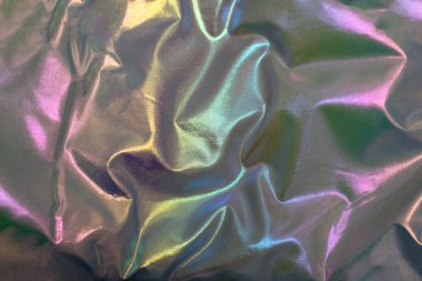 Yumuşak kıvrımlar, gökkuşağı parıltısı ve metalik renk değişimleri içeren canlı yanardöner kumaş dokusu.