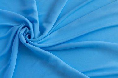 Zarif katlara sarılı pürüzsüz mavi kumaş, arka plan, tekstil ve tasarım projeleri için ideal..