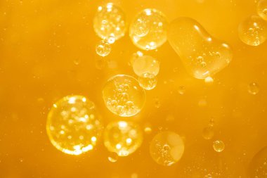 Altın sarısı baloncuk yağ damlası, soyut arkaplan