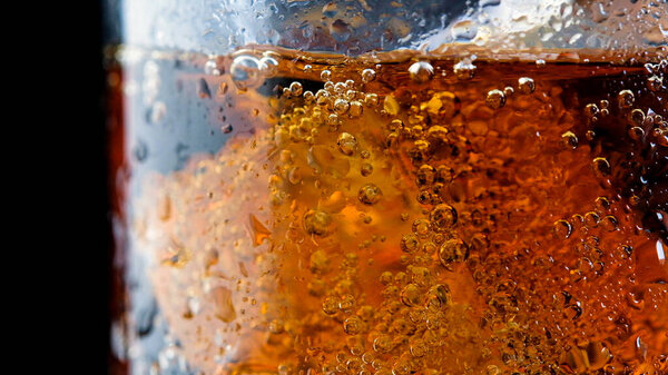 ice cube in fizzy splashing water with soda bubble