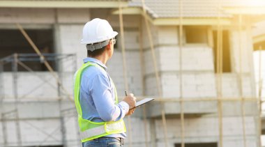 İnşaat alanında dijital tablet üzerinde çalışan mühendis