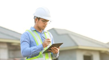 İnşaat alanında dijital tablet üzerinde çalışan mühendis