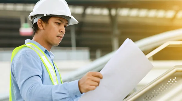 engineer hold blueprint draft paper at construction site