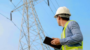 Elektrik Mühendisi Elektrik Santrali Arkaplanı ile Dijital Tablet üzerinde çalışıyor