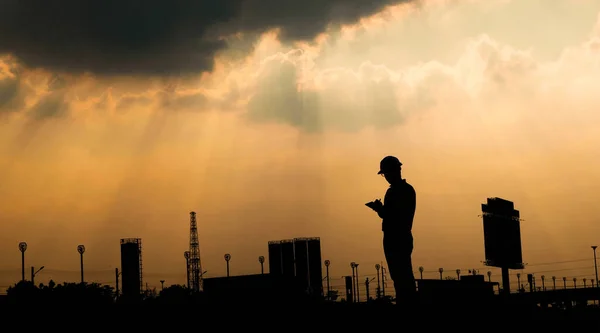 stock image Engineer talk on mobile phone at construction site at sunset silhouette