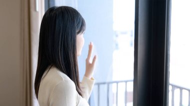 Pencereden bakan genç Asyalı kadın