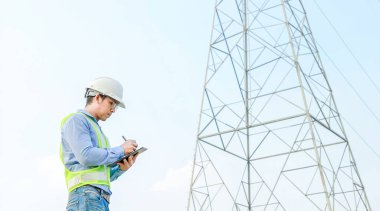 Elektrik Mühendisi Elektrik Santrali Arkaplanı ile Dijital Tablet üzerinde çalışıyor