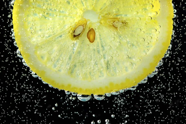 Lemon and line drop in fizzy sparkling water, juice refreshment