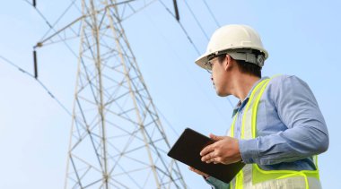 Elektrik Mühendisi Elektrik Santrali Arkaplanı ile Dijital Tablet üzerinde çalışıyor
