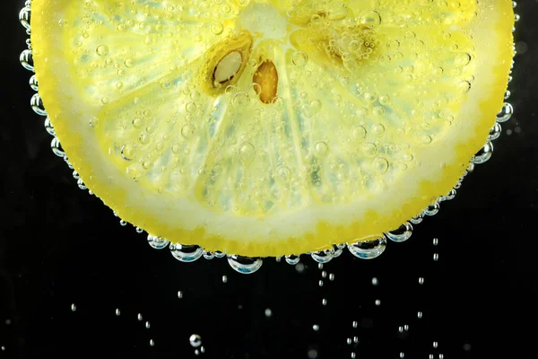 Lemon and line drop in fizzy sparkling water, juice refreshment