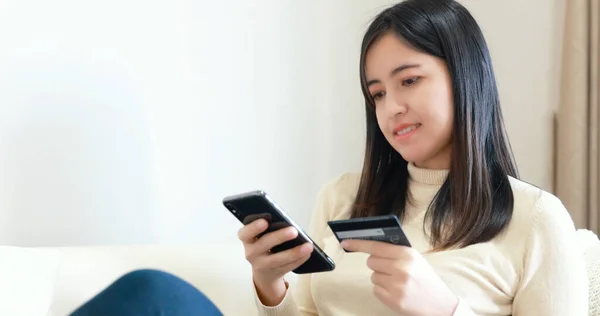 Mujer Sentada Sofá Uso Teléfono Inteligente Tarjeta Crédito Para Compras Fotos de stock