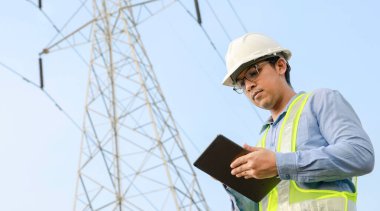 Elektrik Mühendisi Elektrik Santrali Arkaplanı ile Dijital Tablet üzerinde çalışıyor