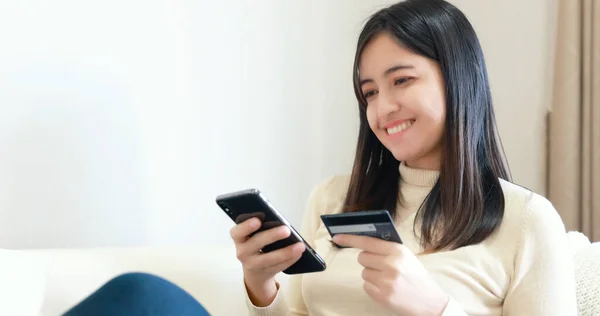 Mujer Sentada Sofá Uso Teléfono Inteligente Tarjeta Crédito Para Compras Imagen de stock