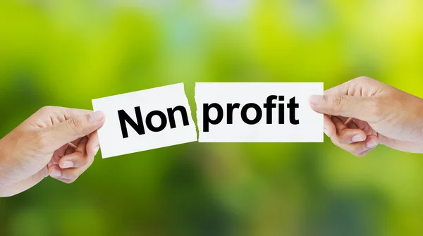 Uomo d'affari strappare la parola Non profit per profitto — Foto Stock