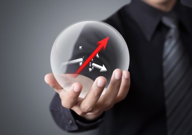 Businessman holds crystal ball with rising and broken graph clipart