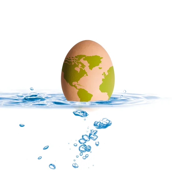 Huevo con caída del mapa del mundo en agua azul — Foto de Stock